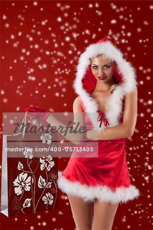 christmas glamour shot of a sexy blonde dresses as female santa claus with a short red dress and red gloves