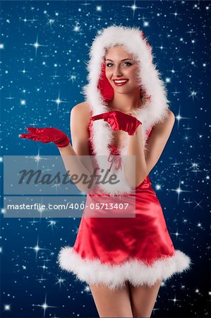 sexy shot of a female santa claus dressed with a red mini dress, hood and gloves smiling