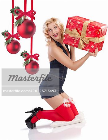 very attractive and sexy blond pin up with red christmas stocking and a big present box sitting on the floor