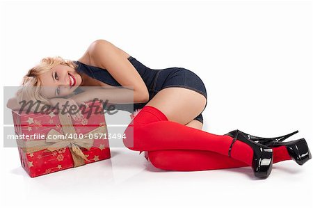 very attractive and sexy blond pin up with red christmas stocking and a big present box laying on the floor
