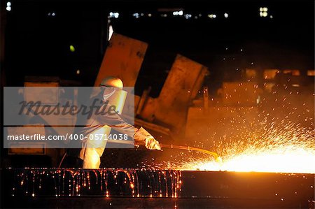 worker using torch cutter to cut through metal