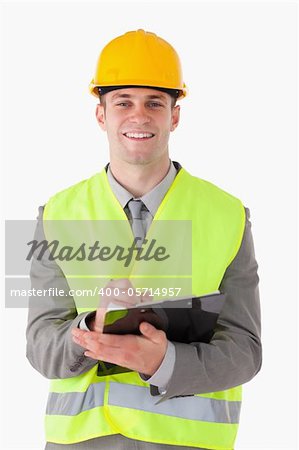 Portrait of a smiling builder taking notes while smiling at the camera