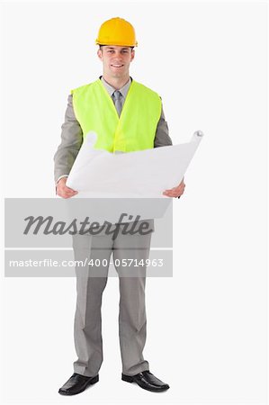 Portrait of a smiling architect looking a plan against a white background