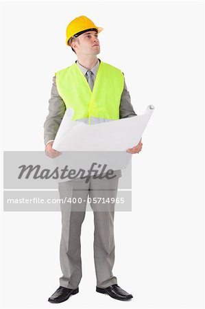Portrait of an architect holding a plan while looking around against a white background