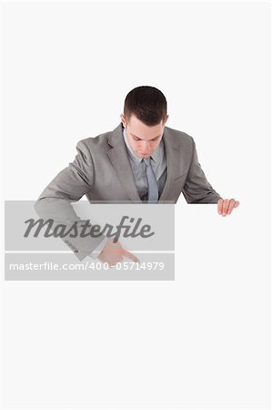 Portrait of a businessman pointing at something on a panel against a white background