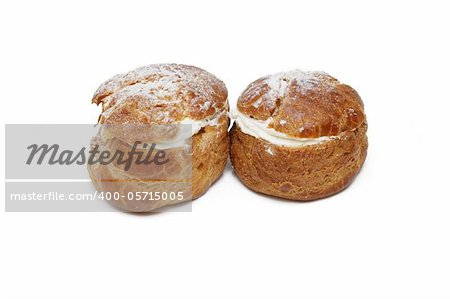 Two pastries filled with custard over white background