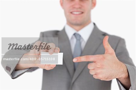 Businessman pointing at a blank business card against a white background