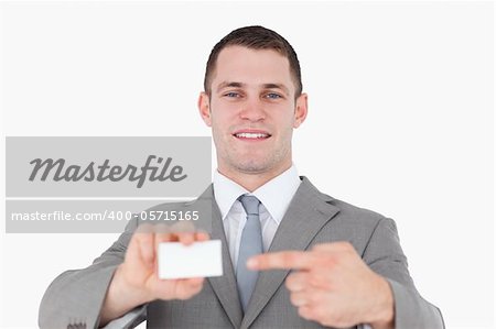 Young businessman pointing at a blank business card against a white background