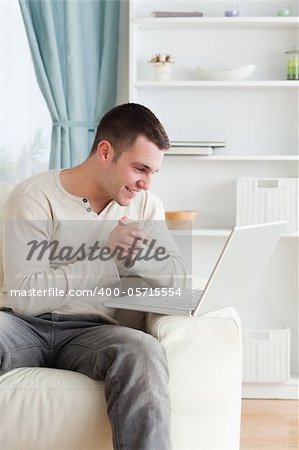 Portrait of a happy man using a notebook in his living room