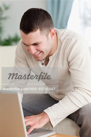 Portrait of a smiling man using a notebook in his living room