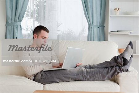 Man relaxing with a laptop in his living room