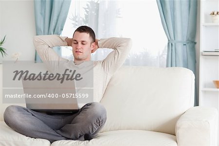 Good looking man using a notebook in his living room