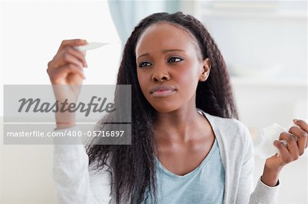 Close up of young woman measuring her temperature