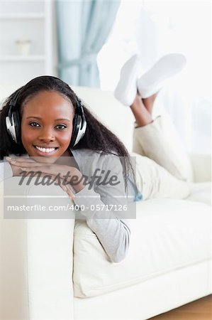 Smiling woman enjoying music on her sofa