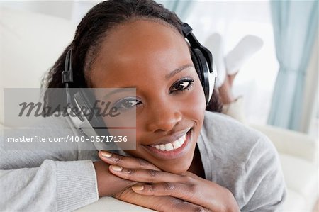 Close up of smiling woman relaxing with music on her couch