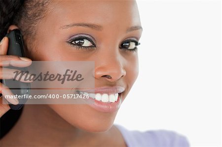 Close up of young woman listening closely to caller on white background