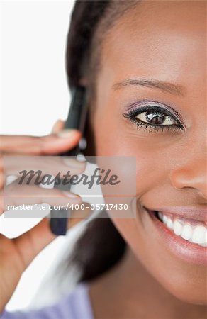 Close up of smiling woman using her phone on white background