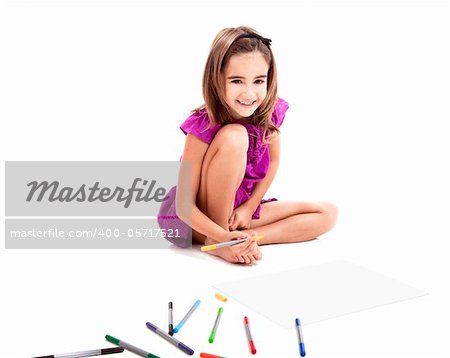 Girl sitting on floor and making drawings on paper