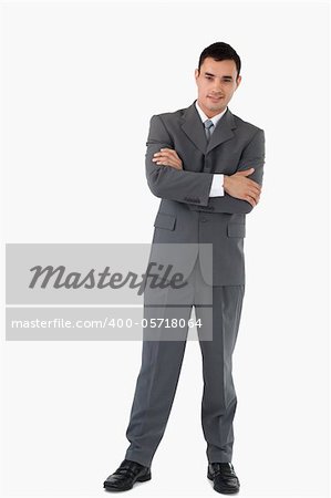 Confident businessman with arms folded against a white background