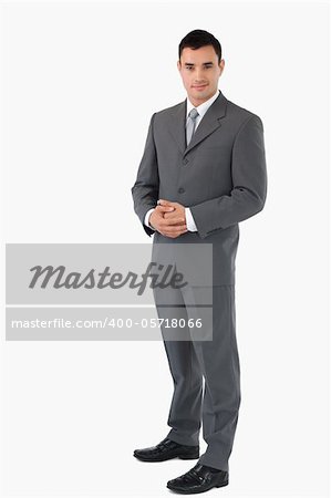 Young businessman with hands folded against a white background