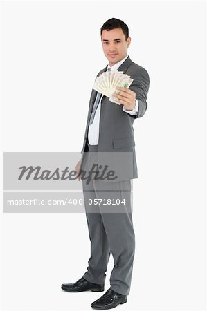 Businessman presenting banknotes against a white background