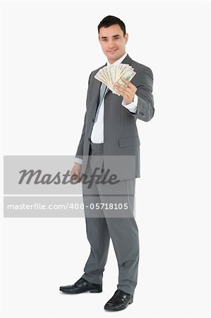 Smiling businessman presenting banknotes against a white background