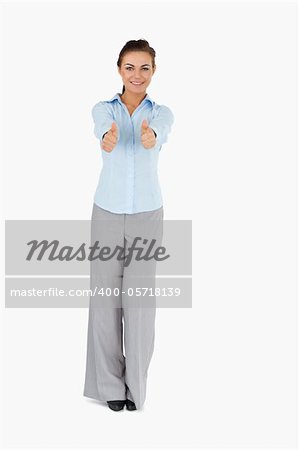 Smiling businesswoman giving thumbs up against a white background