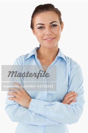 Smiling businesswoman with arms folded against a white background