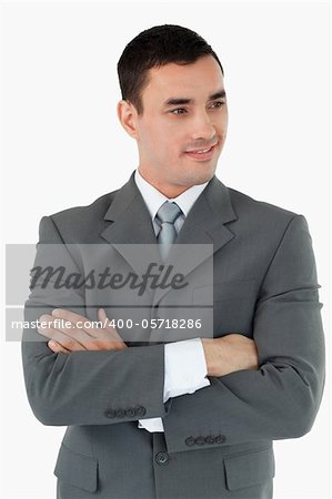 Businessman with arms folded looking to the side against a white background