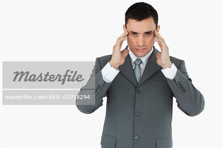 Businessman suffering from a headache against a white background