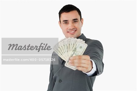 Smiling businessman presenting bank notes against a white background