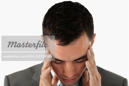 Close up of businessman having a headache against a white background