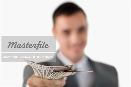 Close up of bank notes being held by businessman against a white background