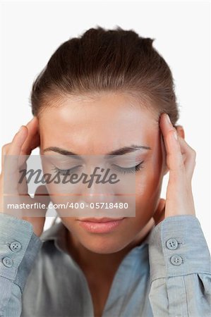Close up of businesswoman suffering from a headache against a white background