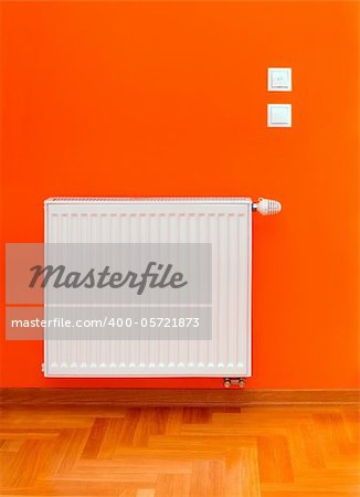 Radiator heater attached on the orange wall