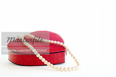 Necklace and case shaped heart on white ground.