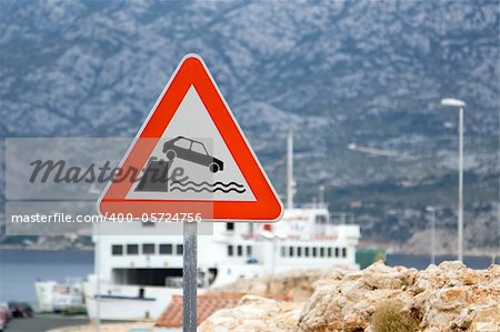 Danger sign with ferryboat station in the background