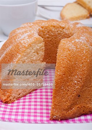 Guglhupf - Traditional Sponge Cake on Plate and Cup on Table Guglhupf - Traditional Sponge Cake on Plate and Cup on Table