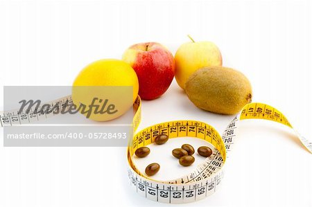 detail of pills and fruit  with measuring tape