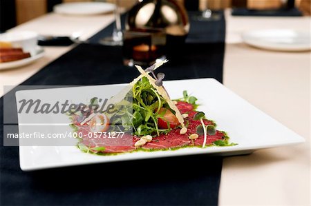 Beef carpaccio with salad and Parmesan cheese