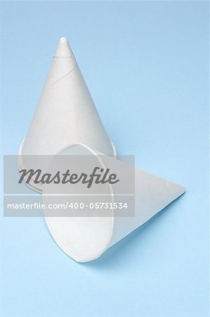 Disposable paper cone water cups on blue background