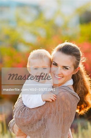 Portrait of happy mother with smiling baby on street