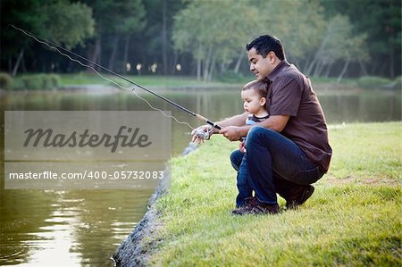 Happy Young Ethnic Father and Son Fishing at the Lake.