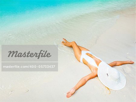 Beautiful woman sunbathing on the sandy beach.