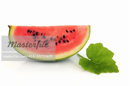 Watermelon fruit slice with leaf sprig isolated over white background.