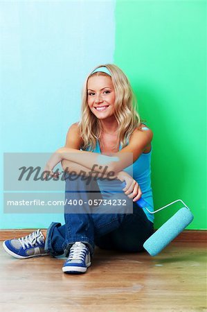 woman paints the wall roller