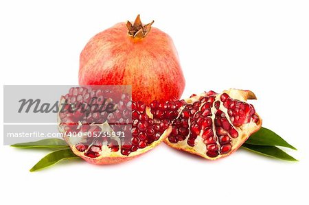 Ripe pomegranate with leaves isolated on white background