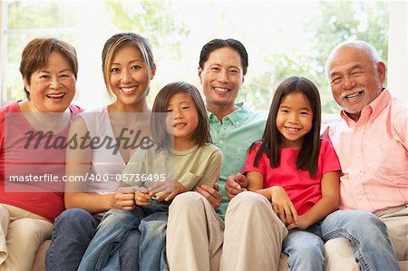 Extended Family Relaxing On Sofa At Home Together