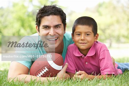 Father And Son In Park With American Football