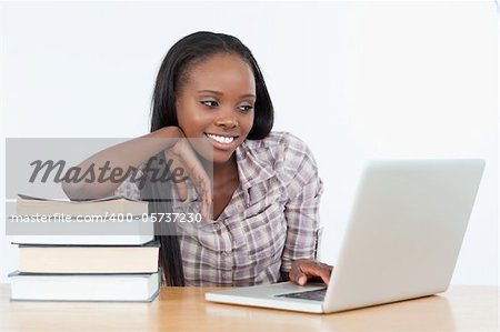 Student woman working with a laptop against a white background